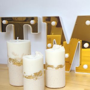 Set de tres velas cilíndricas de cemento y cera de soja artesanal en diferentes tamaños.
