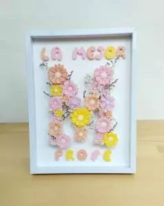 Cuadro decorativo con inicial personalizada hecha con flores de cera de soja aromática en marco de madera.